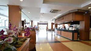 A hotel lobby with a reception desk, seating area, and a large window. - Bangkok City Suite (Bangkok)
