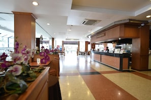 A hotel lobby with a reception desk, seating area, and a large window. - Bangkok City Suite (Bangkok)