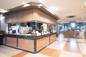 A reception desk with a counter, computers, and a bulletin board in a modern lobby. - Bangkok City Suite (Bangkok)