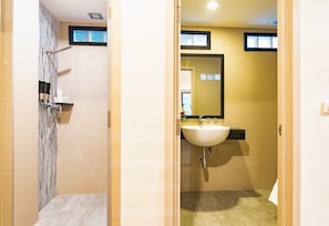A bathroom with a shower, sink, and mirror. - D&D Inn (Bangkok)