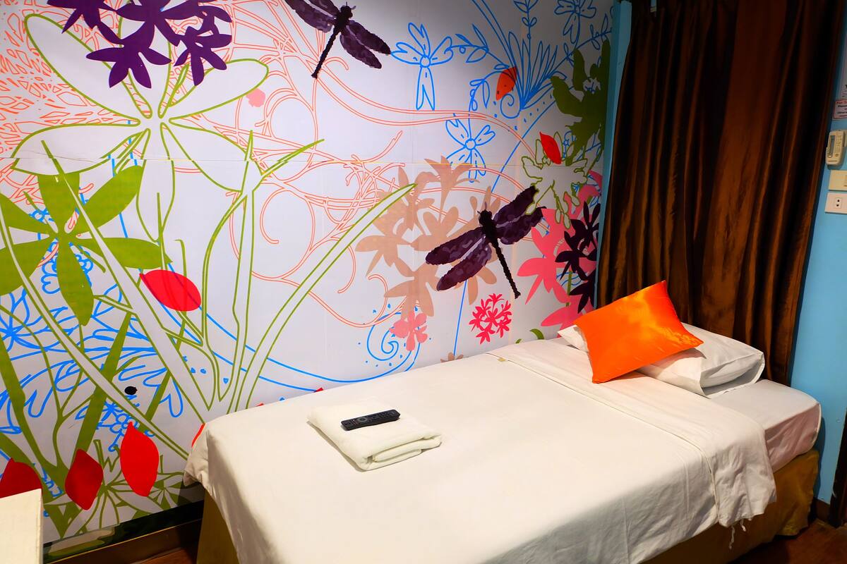 Una habitación de hotel con una cama, un control remoto y una almohada.