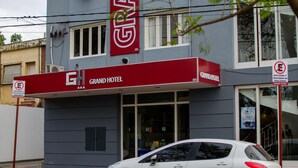 Et hotel med markise i rødt og et skilt, der står "Grand Hotel".