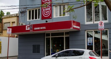 Un hotel con toldo rojo y un letrero que dice "Grand Hotel".
