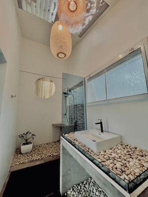 A modern bathroom with a glass shower, a large mirror, and a white sink. - Baan Koh Mak (Ko Mak)