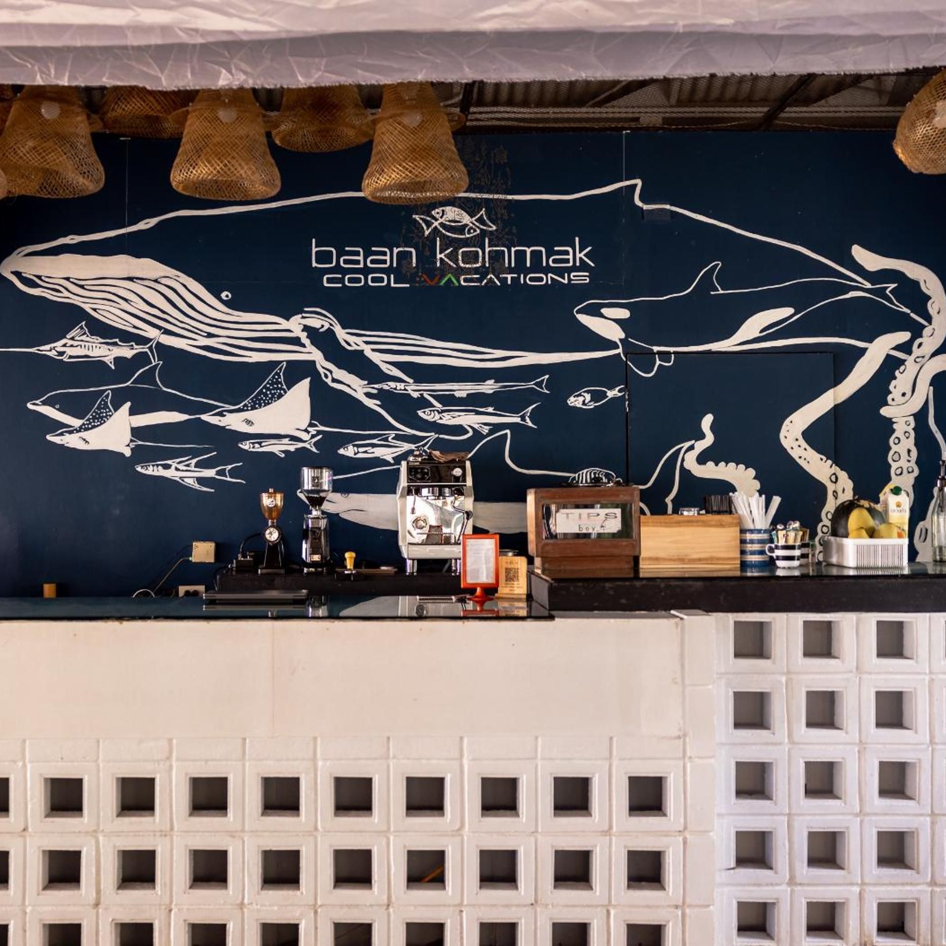 A bar area with a mural of marine life and coffee-making equipment.