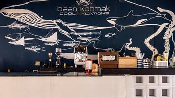 A bar area with a mural of marine life and coffee-making equipment.