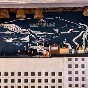 A bar area with a mural of marine life and coffee-making equipment. - Baan Koh Mak (Ko Mak)