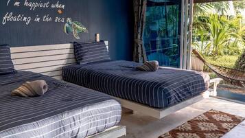 A bedroom with two beds, a large window, and a view of the outdoors.