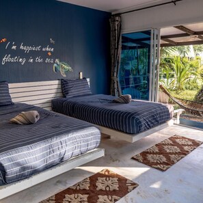 A bedroom with two beds, a large window, and a view of the outdoors. - Baan Koh Mak (Ko Mak)