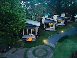 A row of modern, single-story houses with attached porches, surrounded by lush greenery. - Baan Koh Mak (Ko Mak)