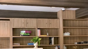 Une bibliothèque moderne avec des étagères en bois, une table en marbre et un espace salon confortable.