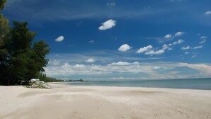 A beach with clear skies, a sandy shore, and trees. - Casuarina Beach Resort (Cha Am)