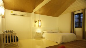 A bedroom with a bed, a nightstand, a lamp, and a window with curtains. - Casuarina Beach Resort (Cha Am)