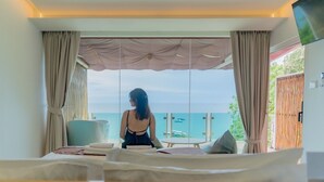 Una habitación con cama, una mesa y vista al mar.
