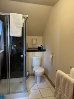 Bañera con ducha, secador de pelo, toallas, papel higiénico