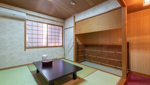 A traditional Japanese room with tatami flooring, a low table, a tea set, and a built-in shelf. - Aqua Garden Hotel Fukumaru (Kagoshima)