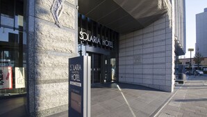 The exterior of Solaria Hotel with a modern facade, large glass entrance, and a prominent signboard.