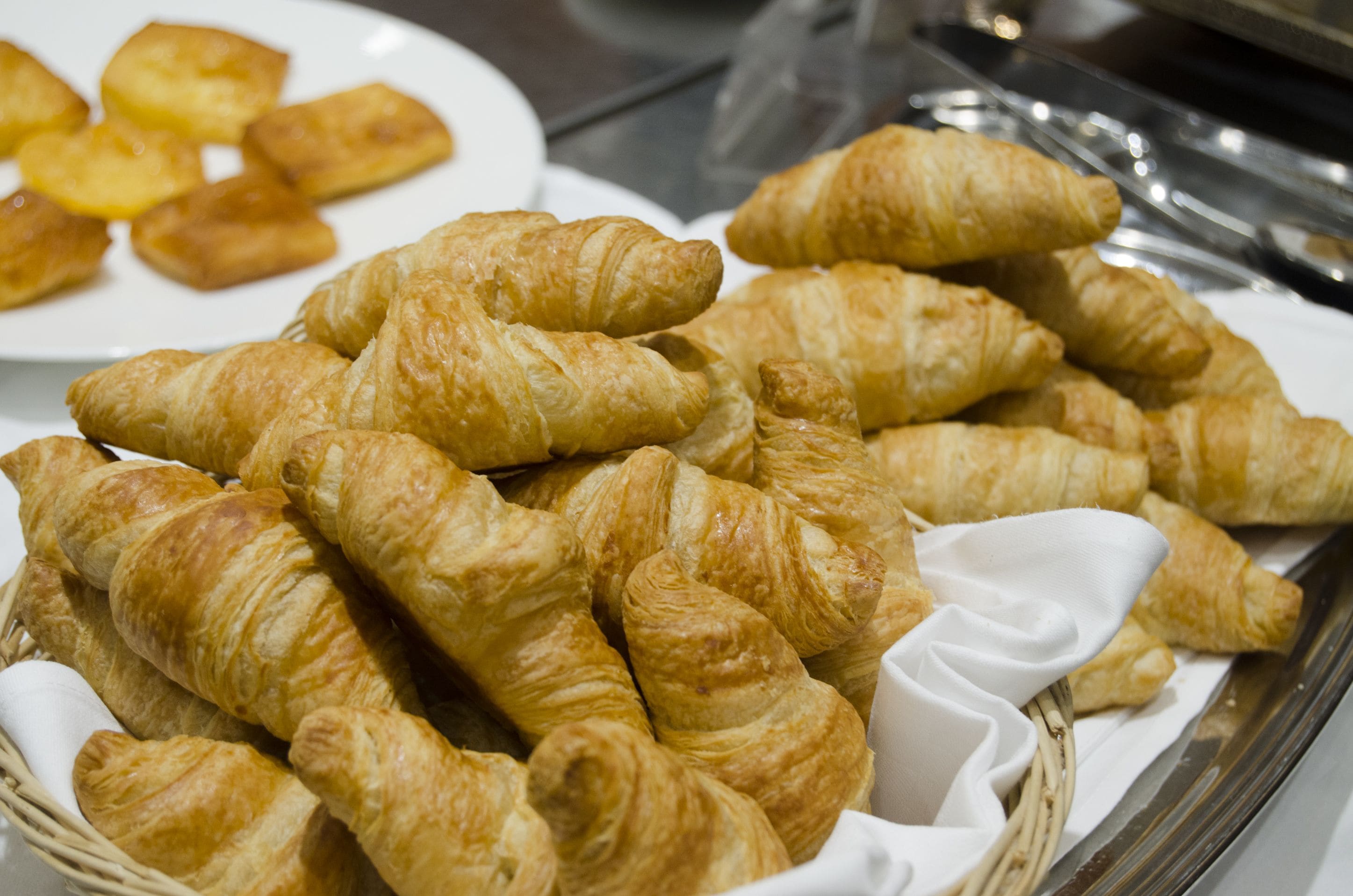 En kurv med croissanter og et fad med kager.