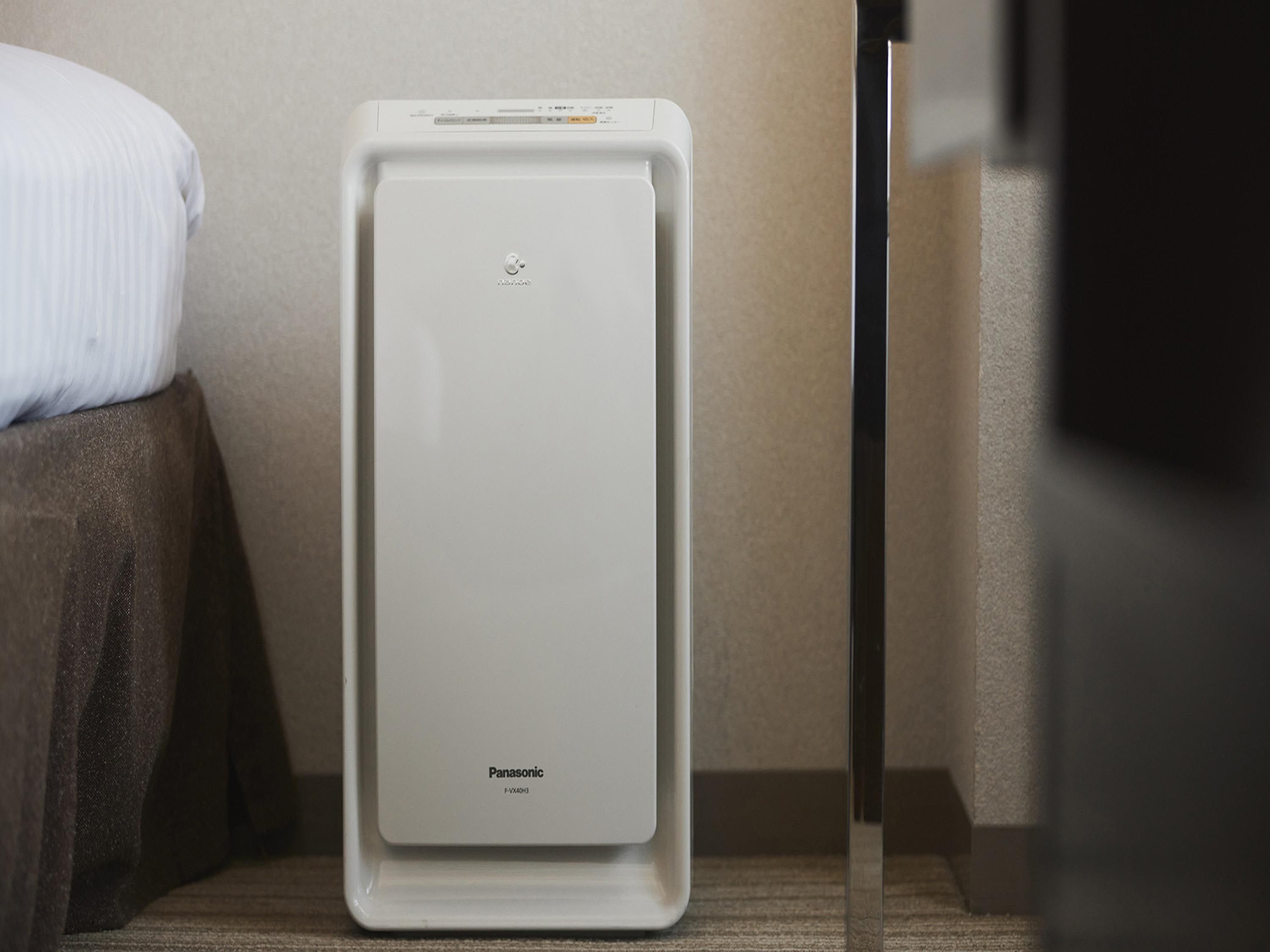 A white portable heater with the brand name 'Panasonic' on a carpeted floor.