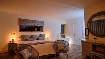 A bedroom with a large bed, two bedside tables, a nightstand, a chair, a dresser, a mirror, and a window with a view.