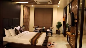 A modern hotel room with a large bed, a desk, and a TV.