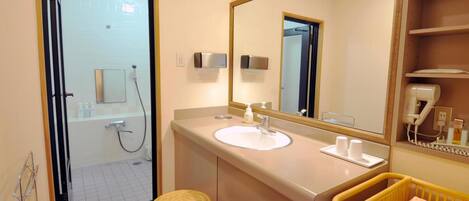 A bathroom with a sink, mirror, and a baby changing station.