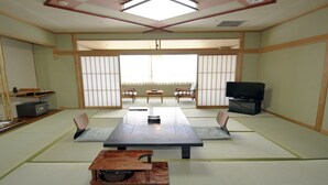 Une pièce de style japonais traditionnel, avec un sol recouvert de tatamis, une table basse et des portes coulissantes.