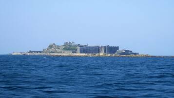 Un hotel costero con varias edificaciones, incluyendo una estructura destacada en una colina y otras más bajas a lo largo de la costa.