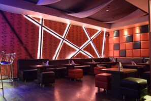 A restaurant with booths, tables, and a patterned wall.