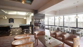 A spacious indoor area with a pool table, billiards, and seating arrangements.