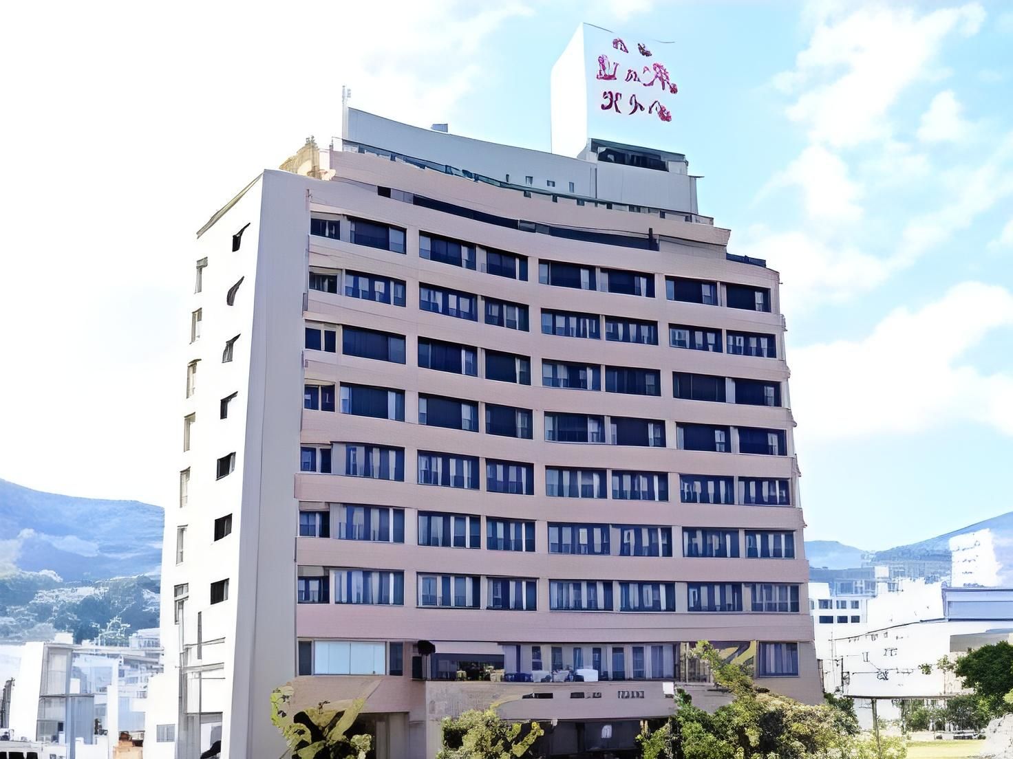 A multi-story hotel building with a flat roof and a sign with Japanese characters.