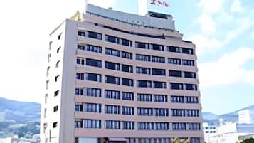 A multi-story hotel building with a flat roof and a sign with Japanese characters.