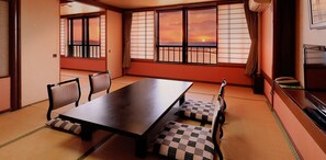 A traditional Japanese room with tatami flooring, a low table, and shoji screens. - Atami Tamanoyu Hotel (Shizuoka)