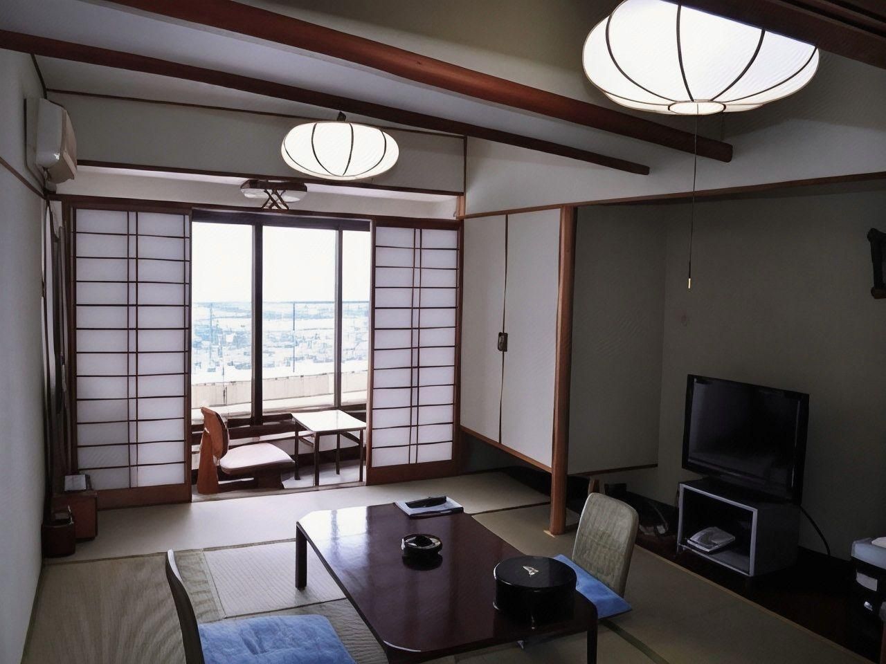 A traditional Japanese room with tatami flooring, a low table, a television, and a sliding door leading to a balcony with a city view.