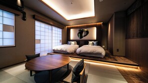 Een moderne slaapkamer met een groot bed, een ronde eettafel en uitzicht op de stad.