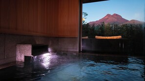 Zona de spa con un jacuzzi y vistas a la montaña.