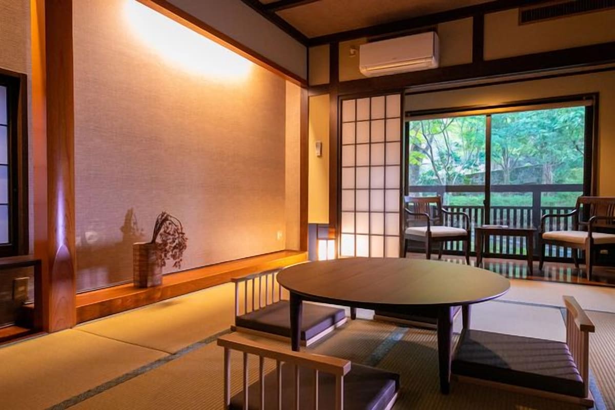 Een traditionele Japanse kamer met tatami vloerbedekking, een lage tafel en schuifdeuren.