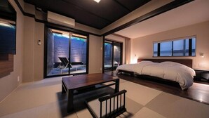 Ein modernes Schlafzimmer mit einem Bett, einem kleinen Tisch und einem Stuhl.