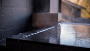 A stone-tiled interior with a reflective water feature. - Yufunogo Saigakukan (Yufu)