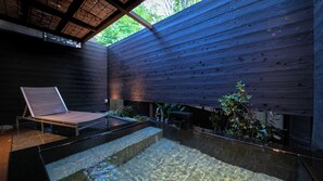 A modern interior with a wooden wall, a glass pool, and a lounge chair. - Yufunogo Saigakukan (Yufu)