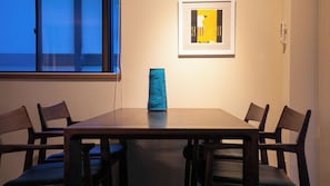 A conference room with a table, chairs, a vase, and a framed picture on the wall. - Yufunogo Saigakukan (Yufu)