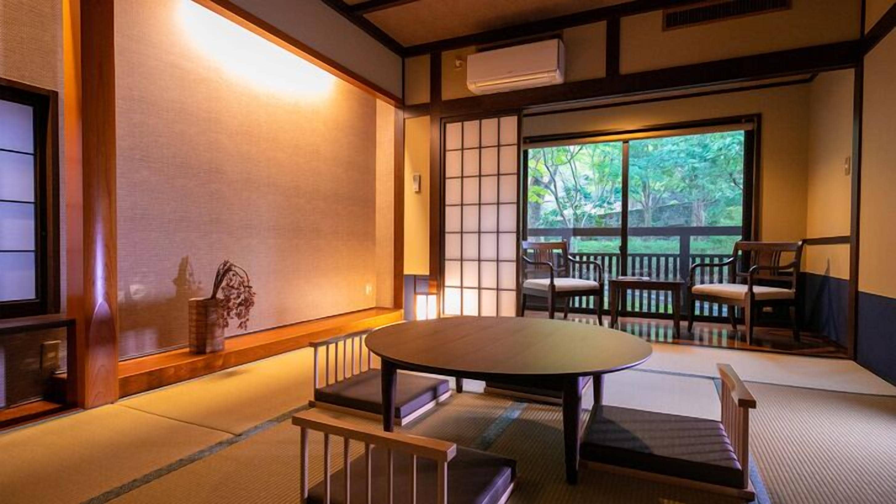 A traditional Japanese room with tatami flooring, a low table, and sliding doors.