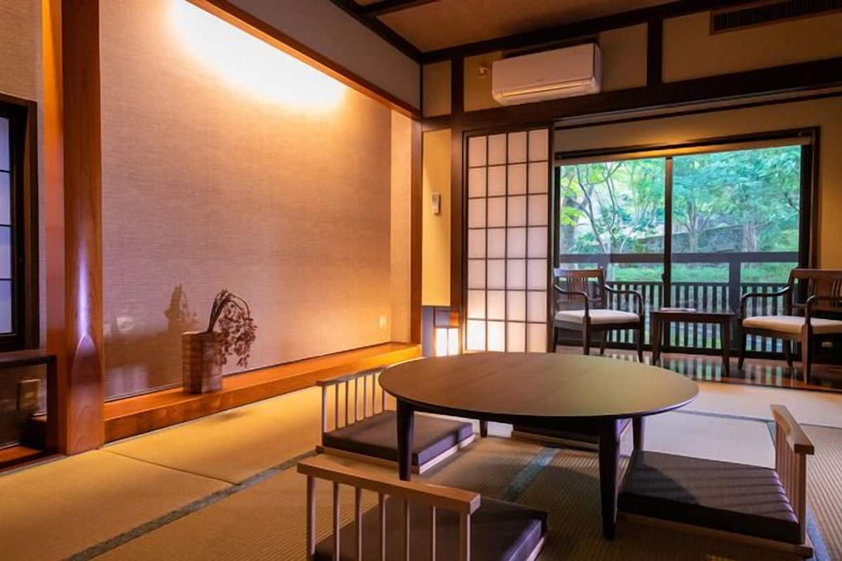 Une pièce de style japonais traditionnel, avec un sol recouvert de tatamis, une table basse et des portes coulissantes.