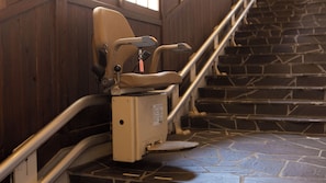 A wheelchair-accessible restroom with a handrail and a stone-tiled floor. - Yufunogo Saigakukan (Yufu)
