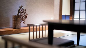 A tatami mat room with a low table and a wooden vase with dried flowers. - Yufunogo Saigakukan (Yufu)