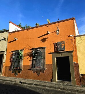 A building with a brown facade, a black door, and barred windows.