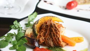 Una mesa de comedor con platos de comida, un vaso de bebida y un tazón de ensalada.