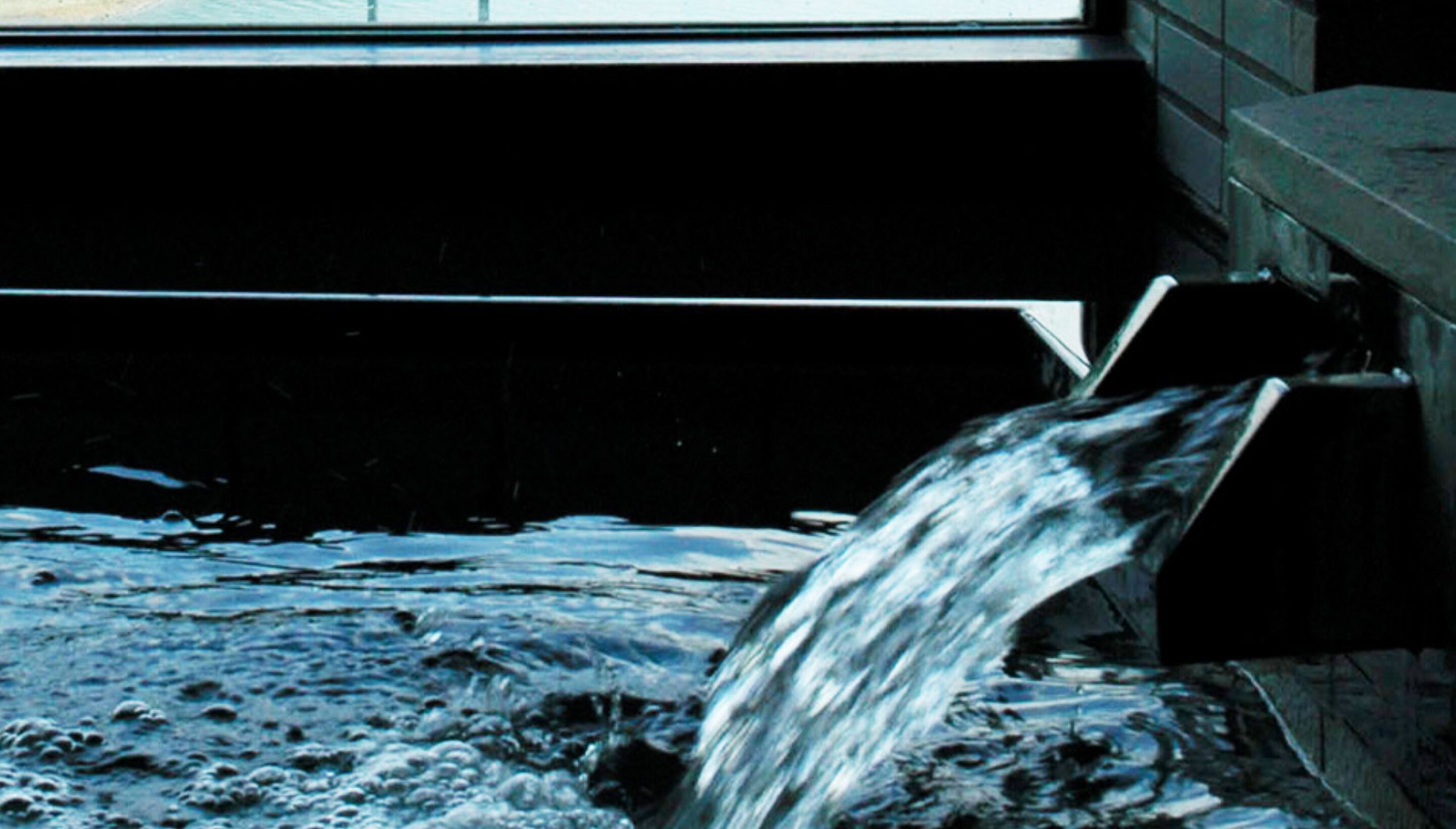 A water stream flowing under a bridge.