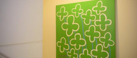 A green artwork with white clover designs on a wall.
