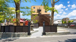 A gated entrance with a stone pathway leading to a building with a modern design. - HOTEL FUJi TORiiGATE (Fujiyoshida)